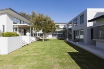 Sunny modern luxury home showcase exterior with courtyard — Stock Photo