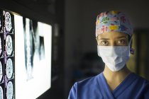 Portrait of young female doctor standing near screen with MRI image — Stock Photo