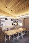 Illuminato soffitto inclinato in legno sopra la cucina — Foto stock