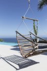 Висящий деревянный стул на роскошном патио с видом на океан — стоковое фото