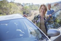 Ritratto di donna anziana felice appoggiata alla macchina — Foto stock