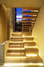 Illuminated modern wood stairs in luxury house — Stock Photo