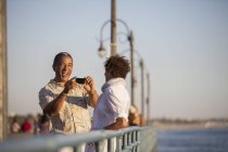 Homme photographiant femme sur quai — Photo de stock