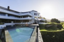 Солнечный современный роскошный дом витрина снаружи с бесконечным бассейном — стоковое фото