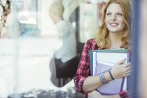 Woman carrying binders outdoors — Stock Photo