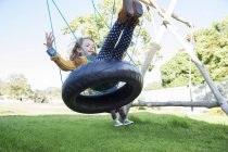 Children playing on tire swings — Stock Photo