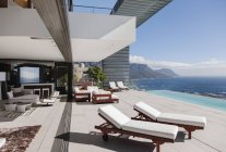 Moderno patio y piscina infinita con vistas al océano - foto de stock