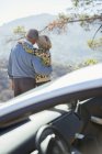 Seniorenpaar schaut sich Bergblick vor Auto an — Stockfoto