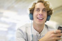 Счастливый молодой человек слушает наушники — стоковое фото