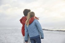 Irmão e irmã afetuosos olhando para o oceano de inverno — Fotografia de Stock