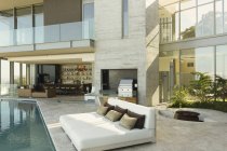 Maison de luxe vitrine patio extérieur avec chaises longues au bord de la piscine — Photo de stock