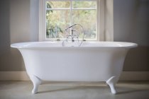 Кіготь ноги ванна в розкішній ванній кімнаті проти вікна — стокове фото