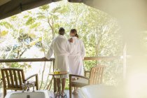 Couple in bathrobes standing in outdoor spa — Stock Photo