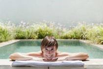 Жінка розслаблюючій в розкішний басейн колінах — стокове фото