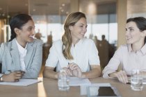 Усміхнені бізнес-леді розмовляють у конференц-залі зустрічі — стокове фото