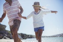 Familie läuft im Wasser am Strand — Stockfoto