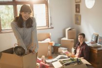 Portrait smiling young couple unpacking moving boxes in apartment — Stock Photo