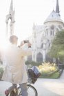 Man photographing Notre Dame Cathedral, Paris, France — Stock Photo