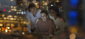 Businesswomen working late at laptop in office at night — Stock Photo