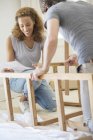 Couple building furniture together — Stock Photo