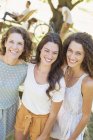 Happy beautiful mother and daughters hugging outdoors — Stock Photo