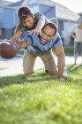 Father and daughter playing football in grass — Stock Photo