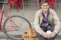 Человек, пьющий кофе на городской улице — стоковое фото