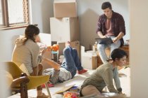 Young friends roommates moving in unpacking boxes in apartment — Stock Photo