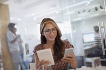 Geschäftsfrau Multitasking mit Smartphone und digitalem Tablet im Büro — Stockfoto