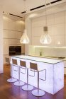 Banquetas de bar e características de luz na cozinha moderna — Fotografia de Stock