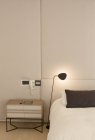Illuminated lamp over bed — Stock Photo