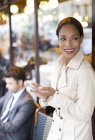 Бізнес-леді, використовуючи мобільний телефон у тротуарному кафе — стокове фото