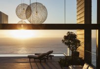 Патио современного дома с видом на океан на закате — стоковое фото