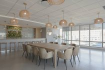 Tavolo conferenze e lampade a sospensione nella moderna sala conferenze — Foto stock