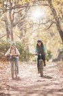 Мати і дочка катаються на велосипеді по шляху в лісі — стокове фото