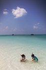 Menino e menina irmão e irmã snorkeling no oceano tropical azul ensolarado — Fotografia de Stock