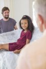 Family lifting couch with young girl sitting on top — Stock Photo