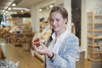 Frau kauft ein, liest Etikett auf Marmeladenglas im Geschäft — Stockfoto