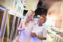 Riendo joven lesbiana pareja disfrutando congelado yogur - foto de stock
