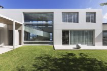 Солнечная современная витрина роскошного дома с травяным двориком — стоковое фото