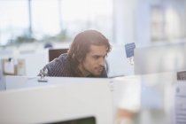 Konzentrierter Geschäftsmann, der am Computer in der Bürokabine arbeitet — Stockfoto