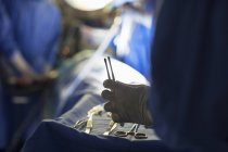 Enfermeira segurando ferramentas cirúrgicas durante a cirurgia — Fotografia de Stock