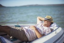 Пожилой человек отдыхает в лодке на воде — стоковое фото