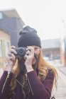 Щаслива молода жінка використовує камеру на міській вулиці — стокове фото
