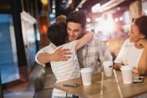 Junges Paar umarmt sich, trinkt Kaffee im Café — Stockfoto