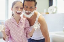 Padre e hija jugando con crema de afeitar - foto de stock
