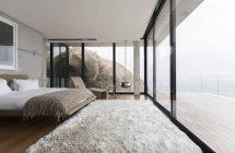 Shag rug and glass walls in modern bedroom — Stock Photo