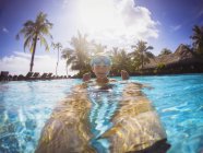 Retrato menino sorridente na piscina tropical ensolarada — Fotografia de Stock