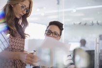 Geschäftsfrauen diskutieren über Papierkram im modernen Büro — Stockfoto