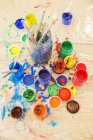 Jars of paint and paintbrushes on wooden table — Stock Photo
